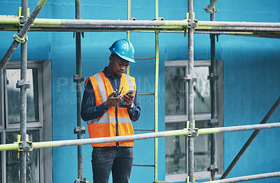 Buy stock photo Male construction worker working checking a digital building plan on a phone. Busy urban development builder looking at buildings planning data to give industry information on a two way radio