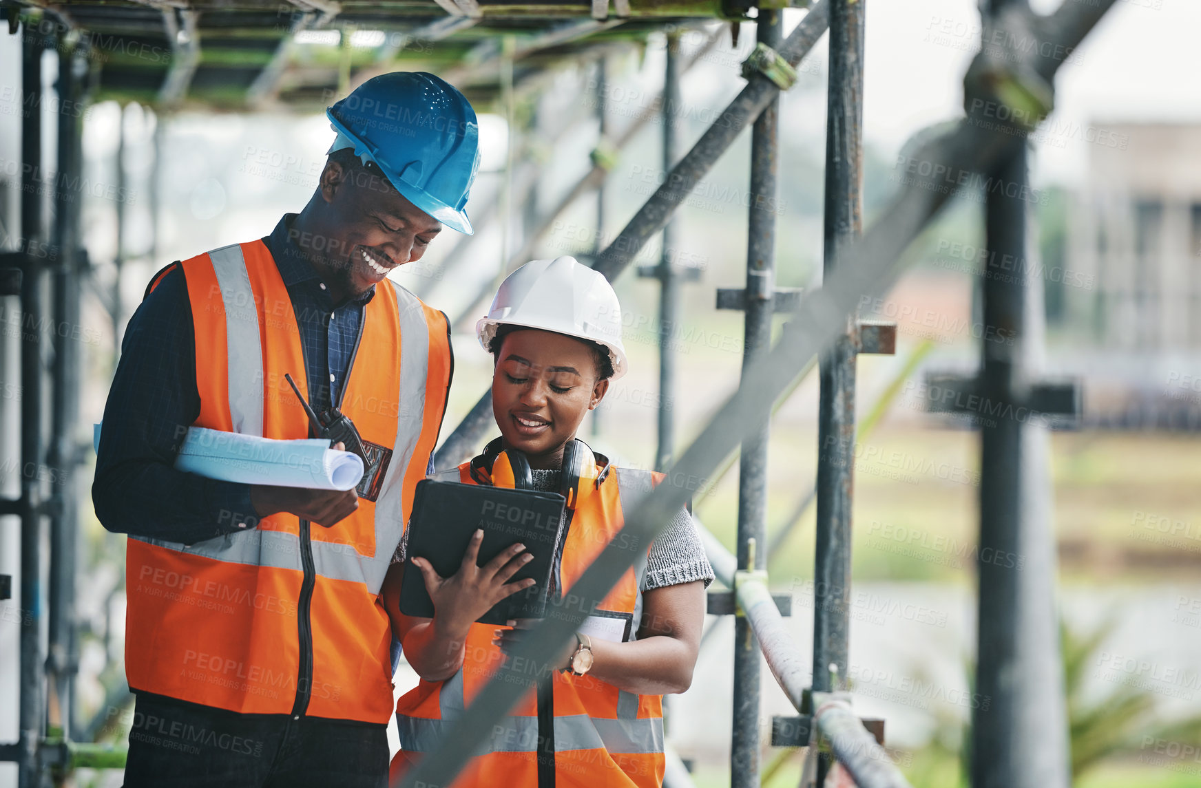 Buy stock photo Shot of a young man and woman using a digital tablet while working at a construction site