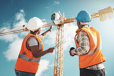 Buy stock photo Construction, engineering and team with tablet and crane for building project, teamwork or architecture. Black woman and man manager talking outdoor for engineer planning, vision or safety inspection