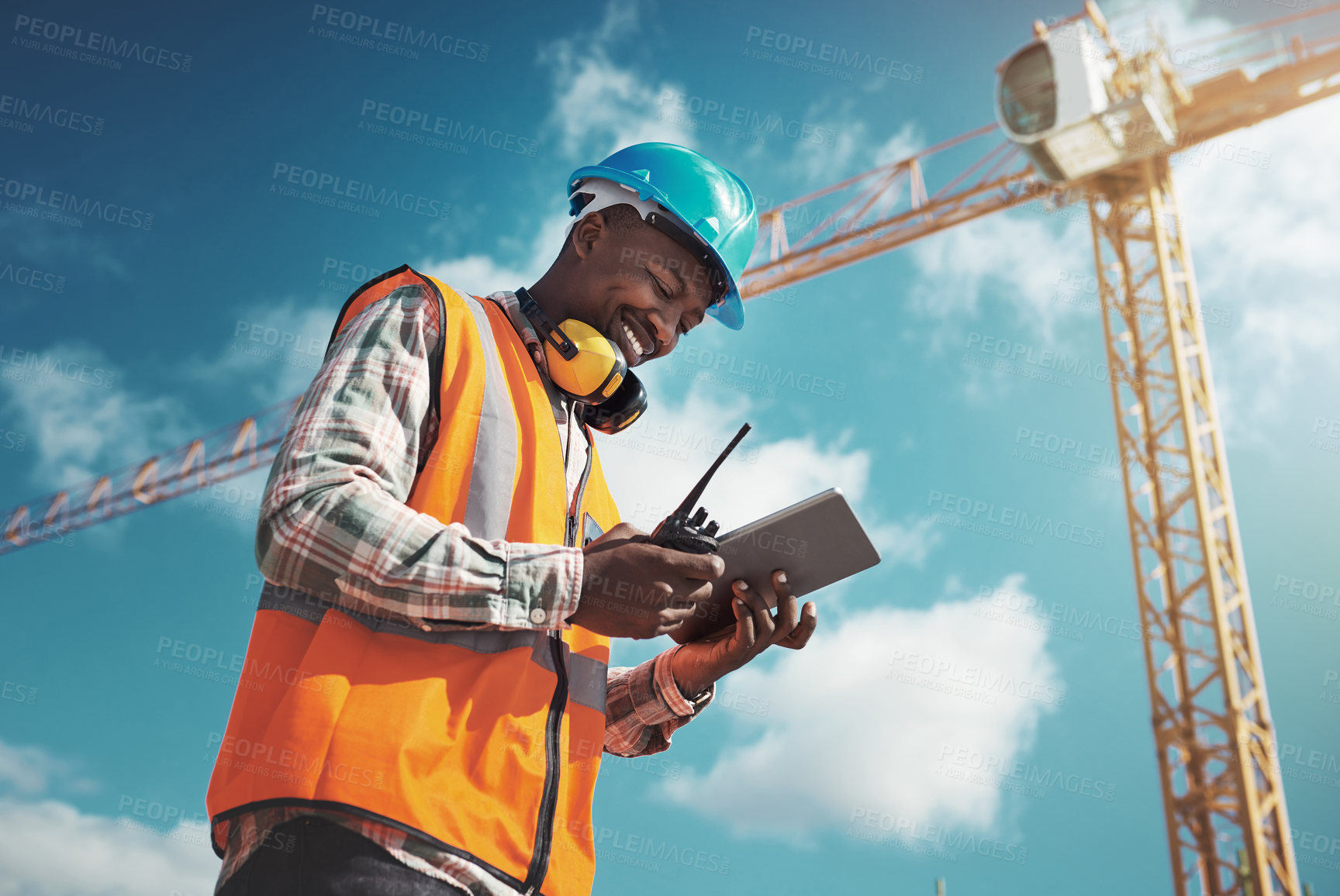 Buy stock photo Shot of a young man using a digital tablet while working at a construction site
