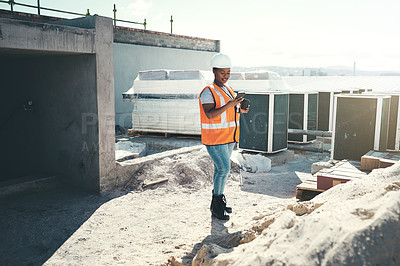 Buy stock photo Shot of a young woman using a smartphone during a coffee break at a construction site