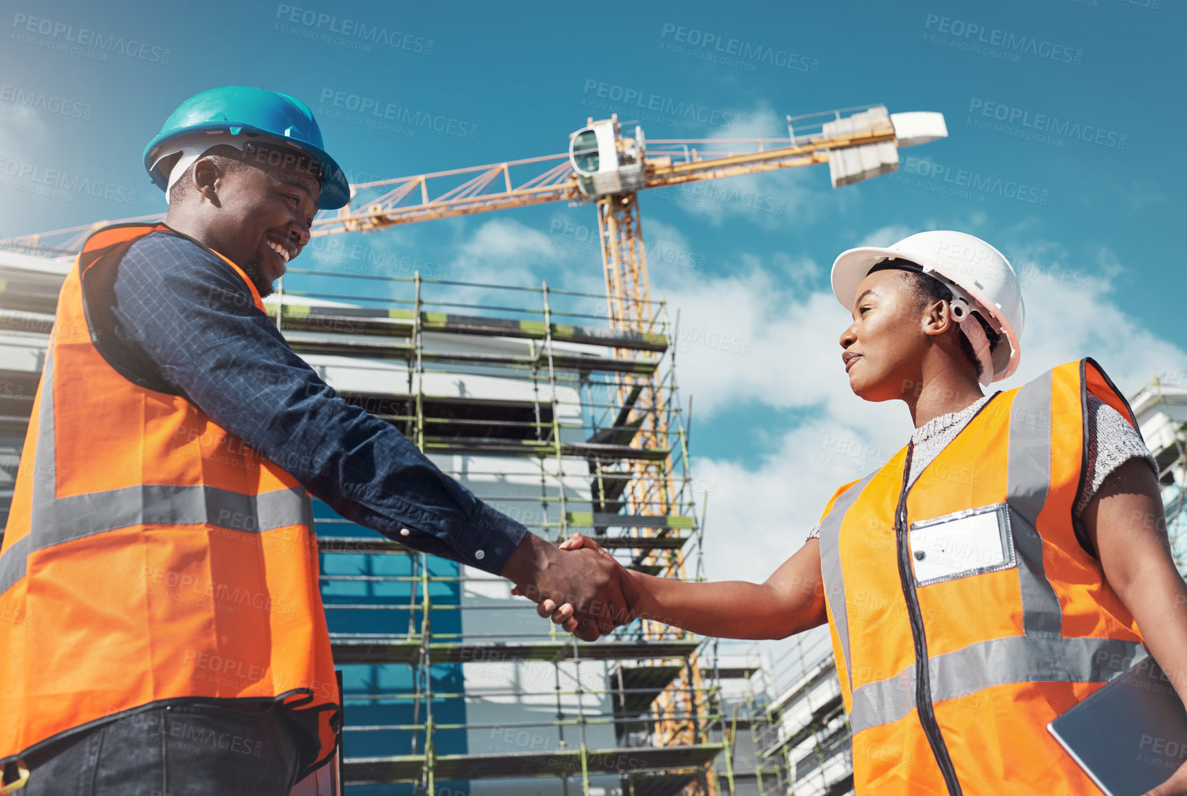 Buy stock photo Shot of two builders shaking hands at a construction site