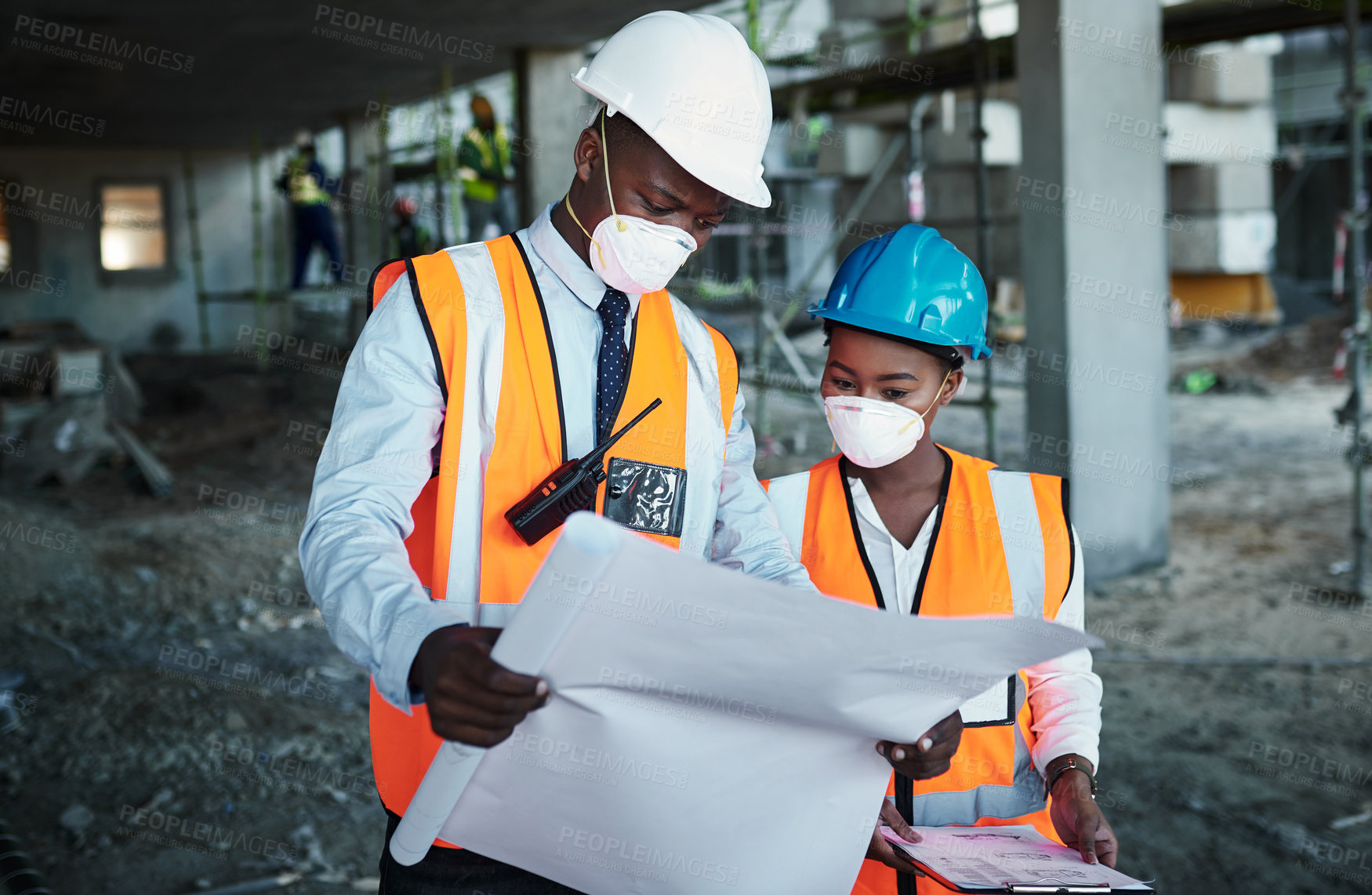 Buy stock photo Shot of a young man and woman going over building plans at a construction site