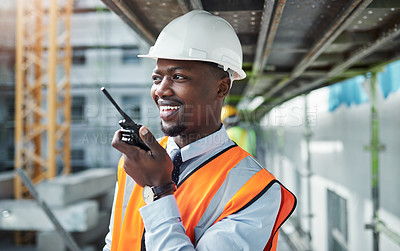 Buy stock photo Shot of a young man using a walkie talkie while working at a construction site