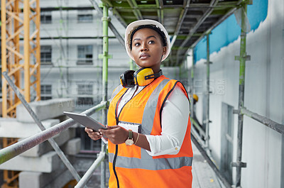 Buy stock photo Shot of a young woman using a digital tablet while working at a construction site
