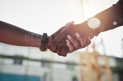 Buy stock photo Shot of two builders shaking hands at a construction site