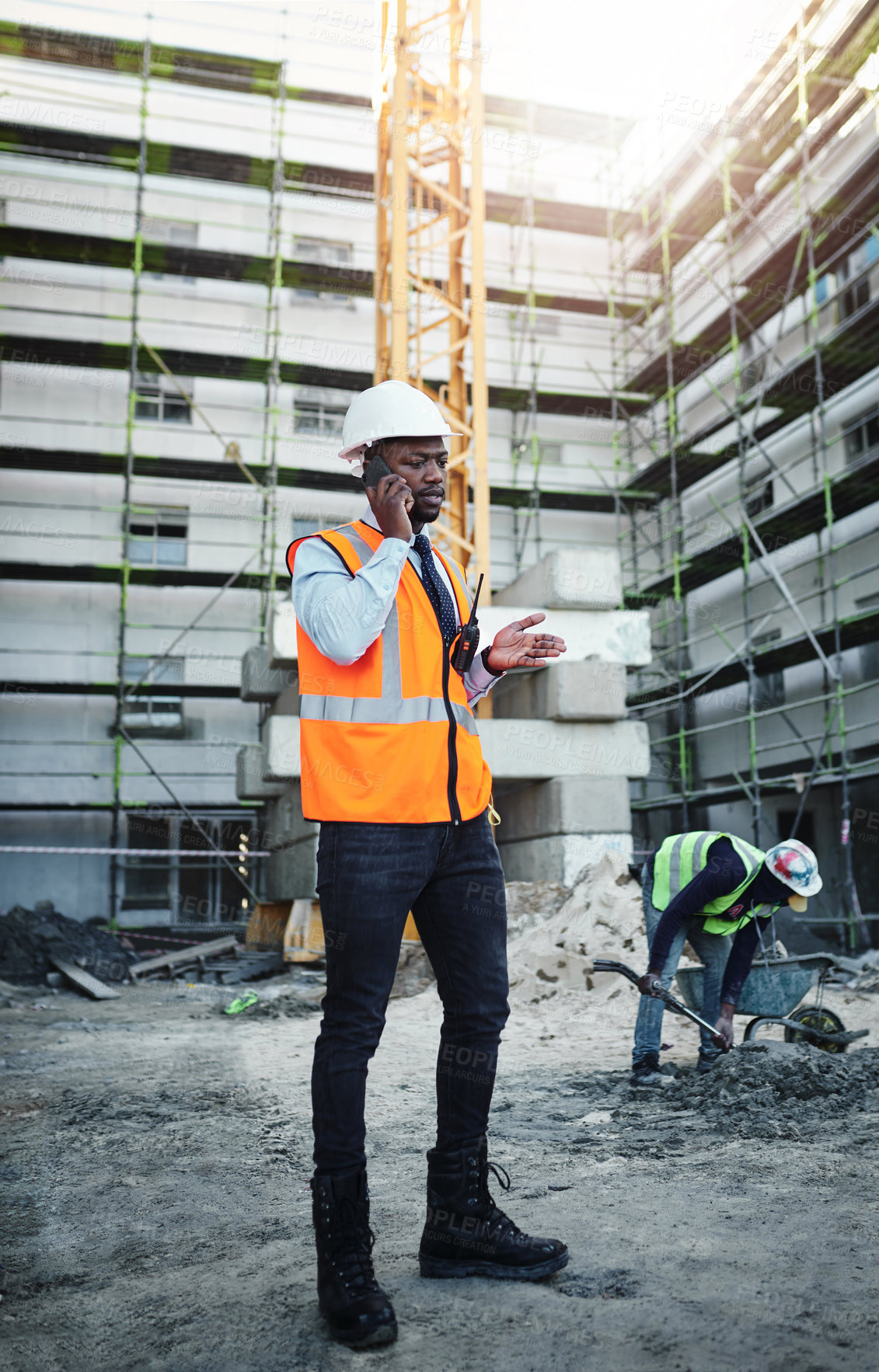 Buy stock photo Black man, architect and talking with phone call on site for communication, construction or maintenance in city. Young African, civil engineer or builder with mobile smartphone for industrial job