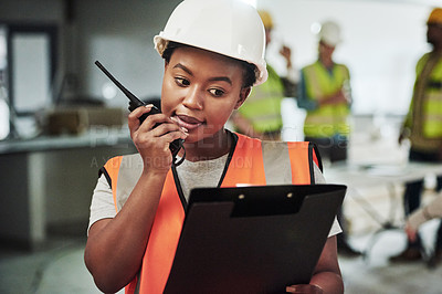 Buy stock photo Shot of a young woman using a walkie talkie while working at a construction site