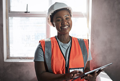 Buy stock photo Shot of a young woman using a digital tablet while working at a construction site