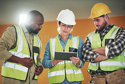 Buy stock photo Shot of a group of builders using a digital tablet while working at a construction site