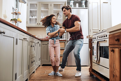 Buy stock photo Shot of a man and his young daughter dancing in the kitchen at home