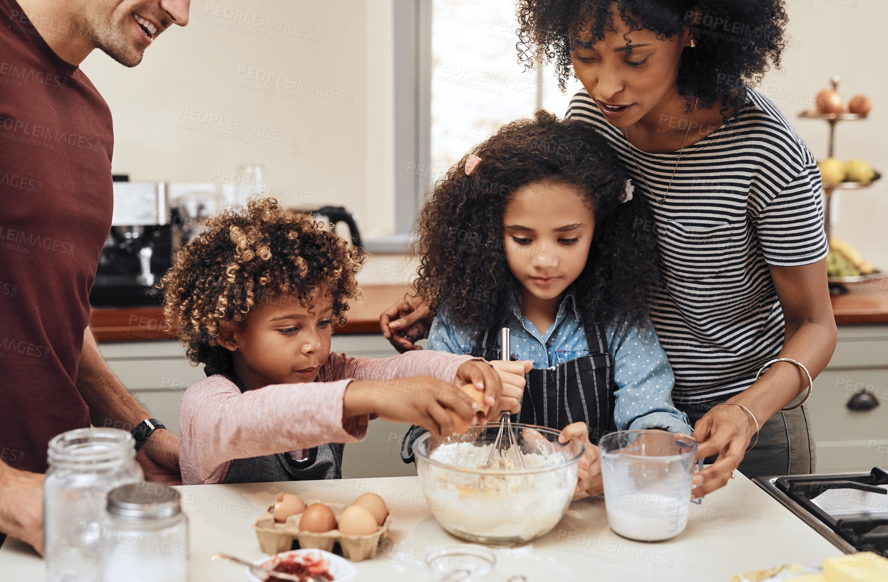 Buy stock photo Cropped shot of a young couple baking at home with their two children