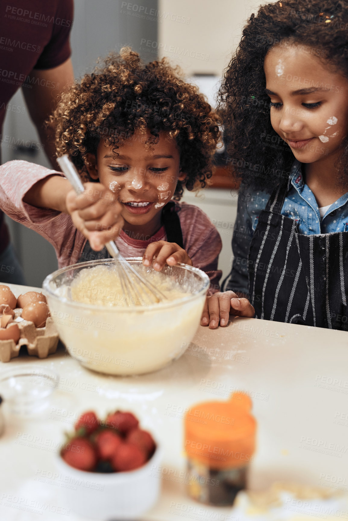 Buy stock photo Cropped shot of a young boy and girl baking in the kitchen at home