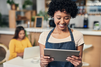 Buy stock photo Shot of a young woman using a digital tablet while working in a cafe