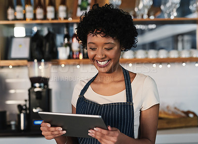 Buy stock photo Shot of a young woman using a digital tablet while working in a cafe