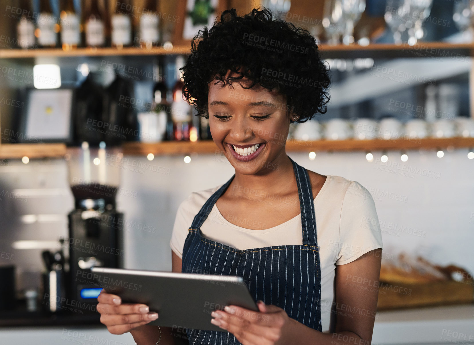 Buy stock photo Shot of a young woman using a digital tablet while working in a cafe