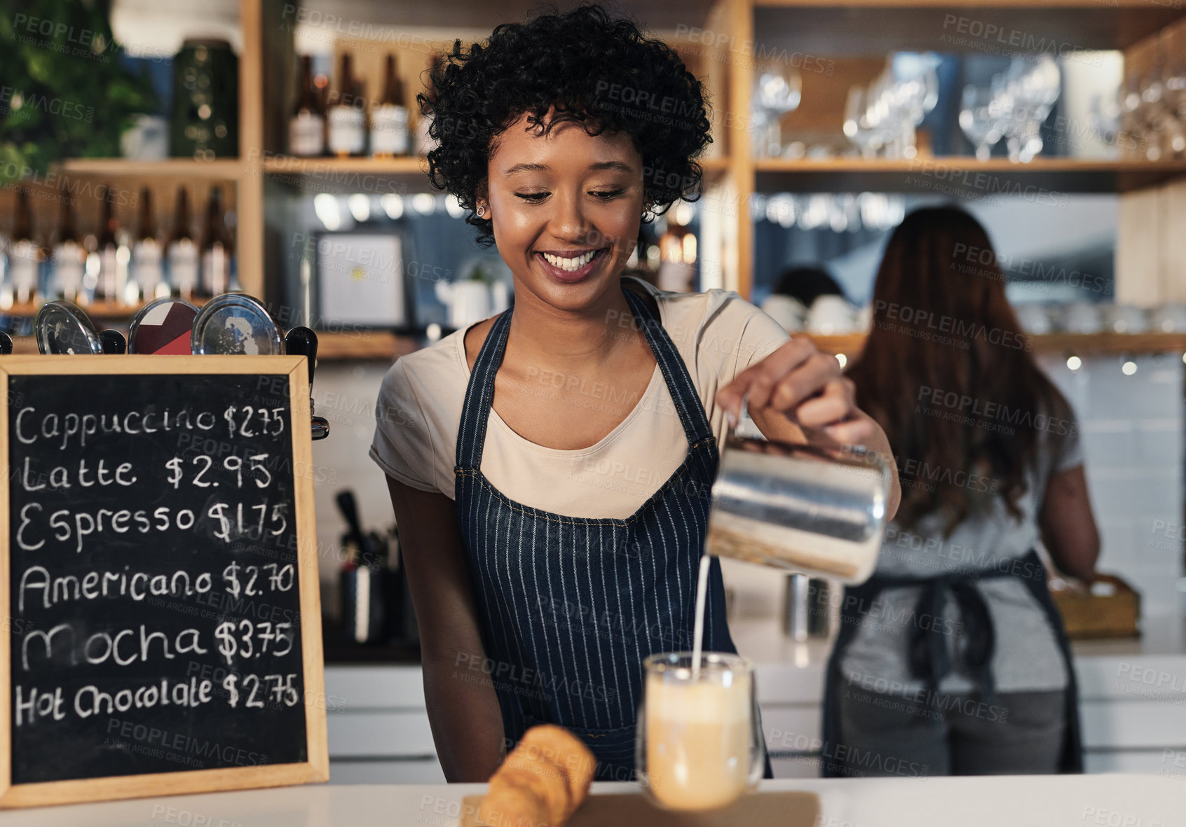 Buy stock photo Shot of a young woman preparing a cup of coffee in a cafe