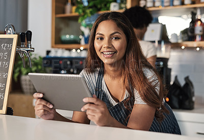 Buy stock photo Portrait of a young woman using a digital tablet while working in a cafe
