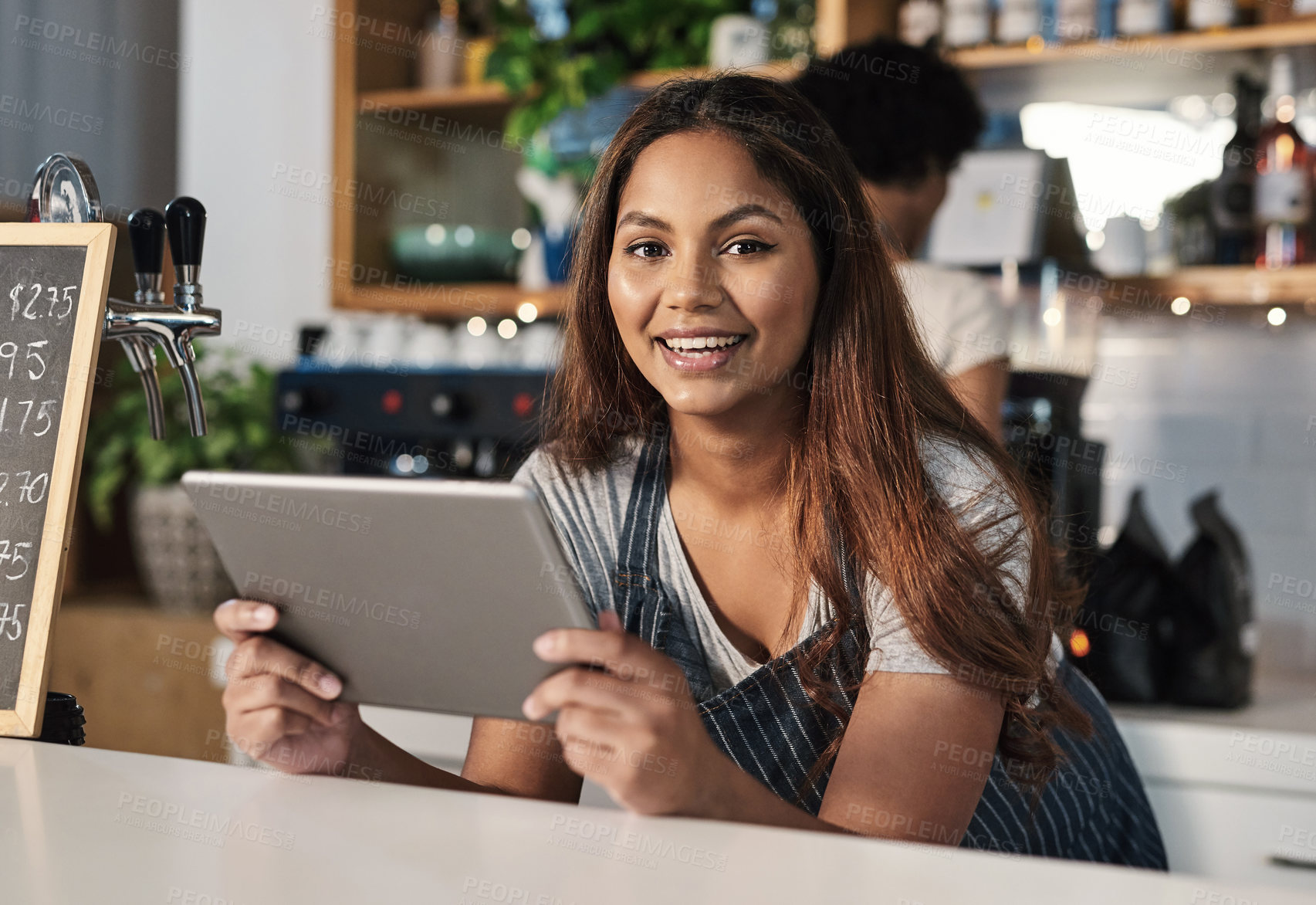 Buy stock photo Portrait of a young woman using a digital tablet while working in a cafe