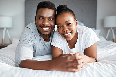 Buy stock photo Portrait of an affectionate young couple relaxing on their bed together at home
