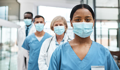 Buy stock photo Portrait of a group of medical practitioners wearing face masks while standing together in a hospital
