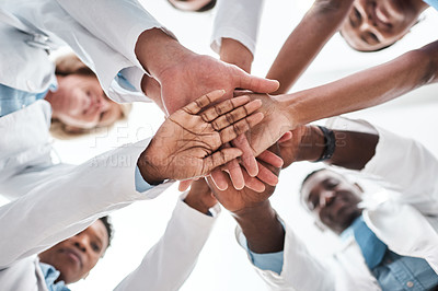 Buy stock photo Closeup shot of a group of medical practitioners joining their hands together in a huddle