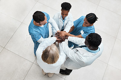 Buy stock photo High angle shot of a group of medical practitioners joining their hands together in a huddle