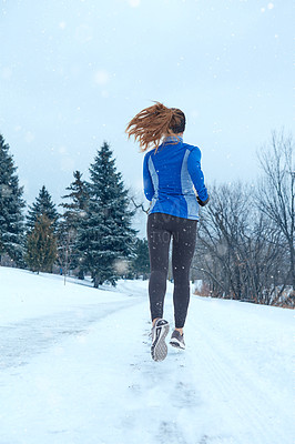 Buy stock photo Shot of a woman wearing warm clothing while out for a run through the snow