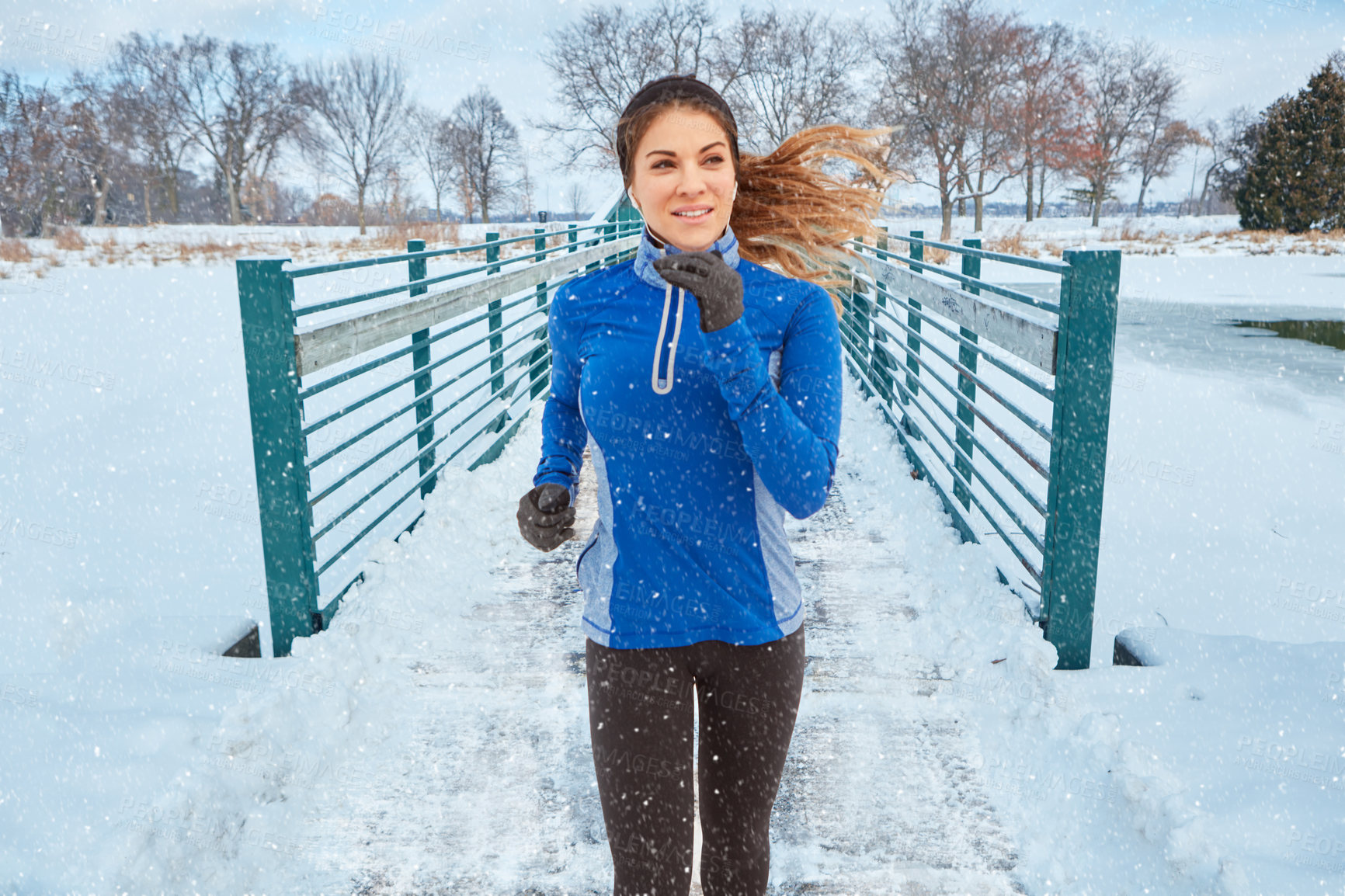 Buy stock photo Shot of a woman wearing warm clothing while out for a run through the snow