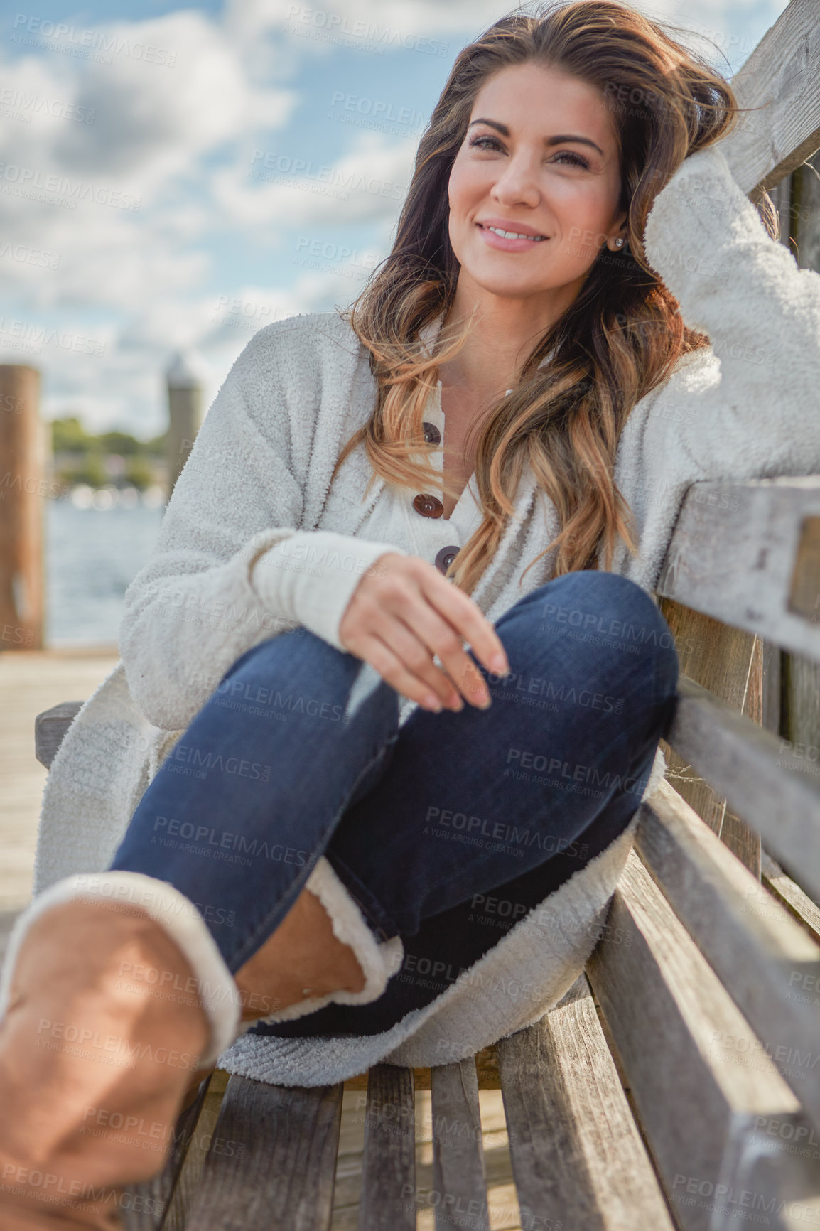 Buy stock photo Shot of a beautiful young woman relaxing on a bench outdoors