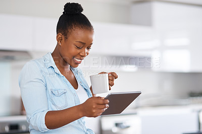 Buy stock photo Shot of a woman drinking coffee while using a digital tablet at home