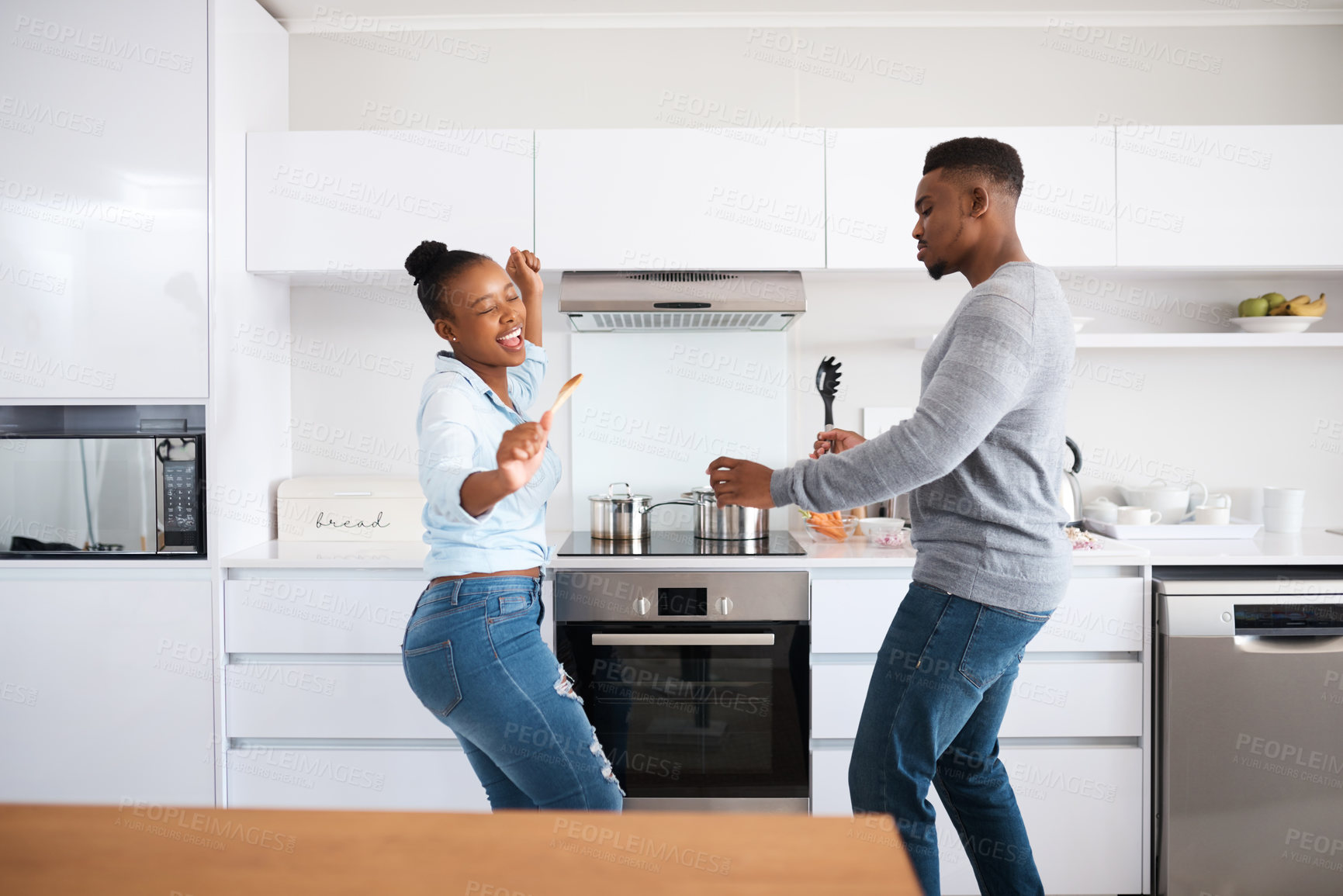 Buy stock photo Black couple, dancing and home for love, energy and music for weekend rhythm in kitchen. Happy people, fun and romance in partnership or relationship, connection and spoons for singing together