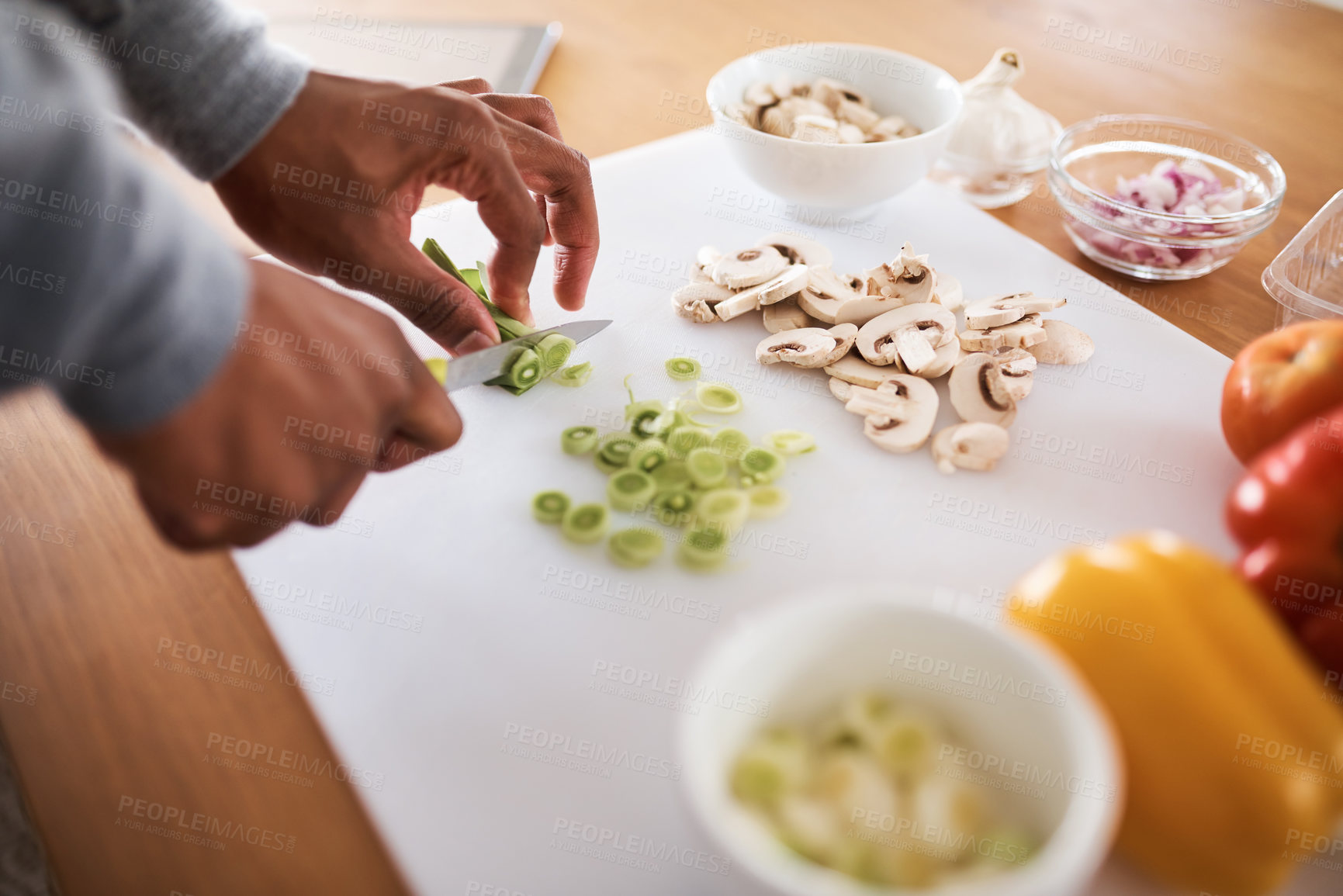 Buy stock photo Cropped shot of an unrecognizable chopping vegetables at home