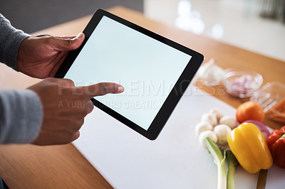 Buy stock photo Shot of an unrecognizable man using a digital tablet while cooking at home