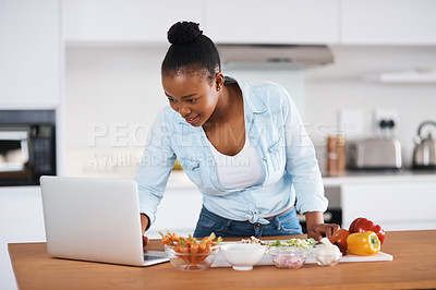 Buy stock photo Black woman, laptop and cooking meal in kitchen, search online recipe and vegetables for nutrition. Female person, ingredients and food in home, vegan cuisine and meal prep or reading instructions