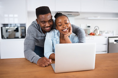 Buy stock photo Shot of a young couple looking at something on a laptop