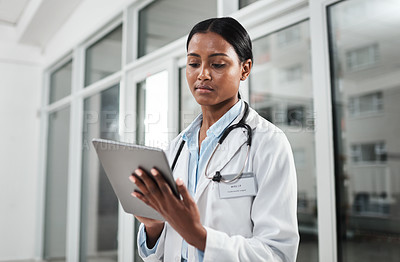 Buy stock photo Shot of a young doctor using a digital tablet in a hospital