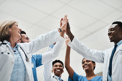 Buy stock photo Shot of a group of medical practitioners giving each other a high five