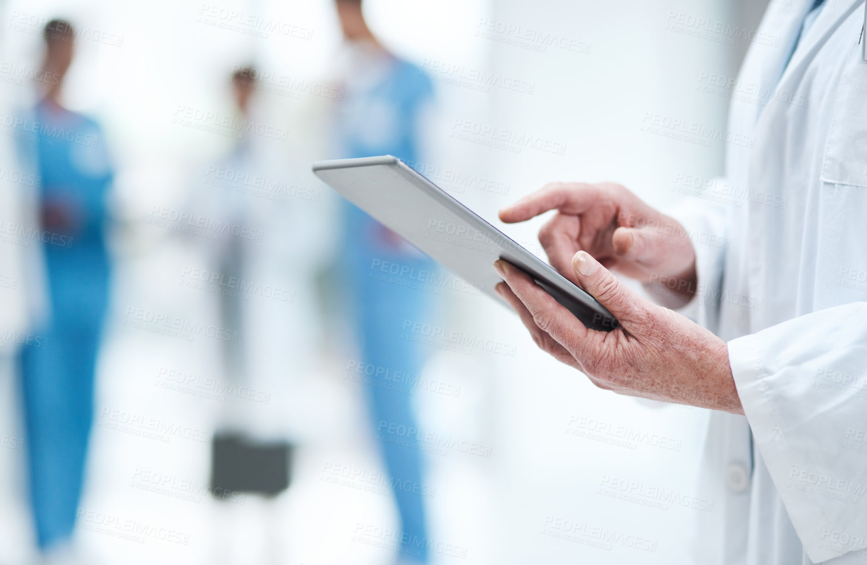 Buy stock photo Closeup shot of an unrecognisable doctor using a digital tablet in a hospital