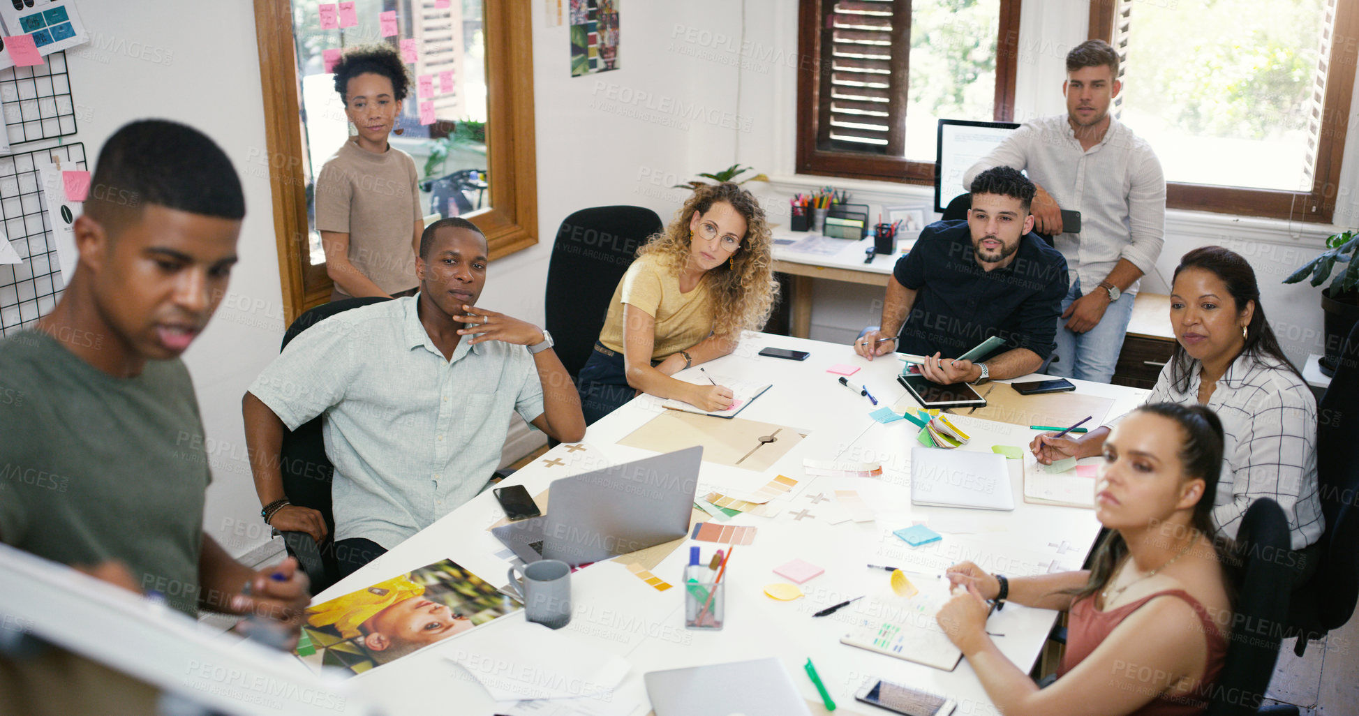 Buy stock photo Shot of a young businessman having a brainstorming session with his colleagues in a modern office