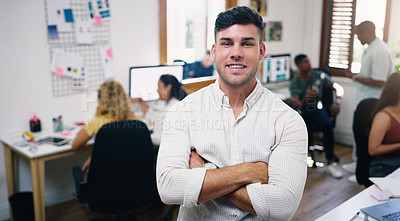 Buy stock photo Portrait of a confident young businessman working in a modern office with his team in the background