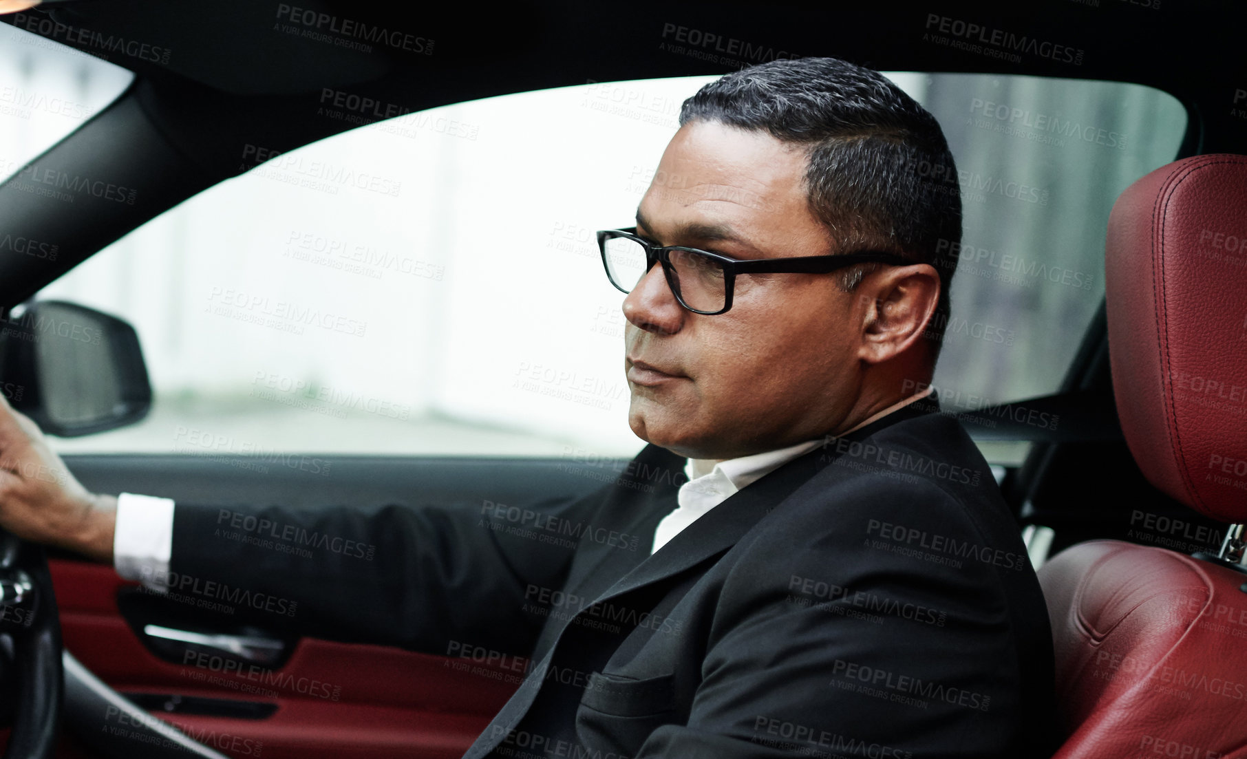 Buy stock photo Cropped shot of a handsome mature businessman driving his car on his morning commute to work