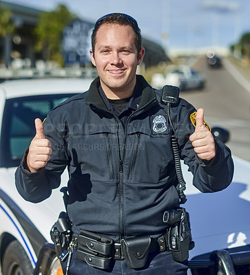 Buy stock photo Cropped portrait of a handsome young policeman giving thumbs up while out on patrol