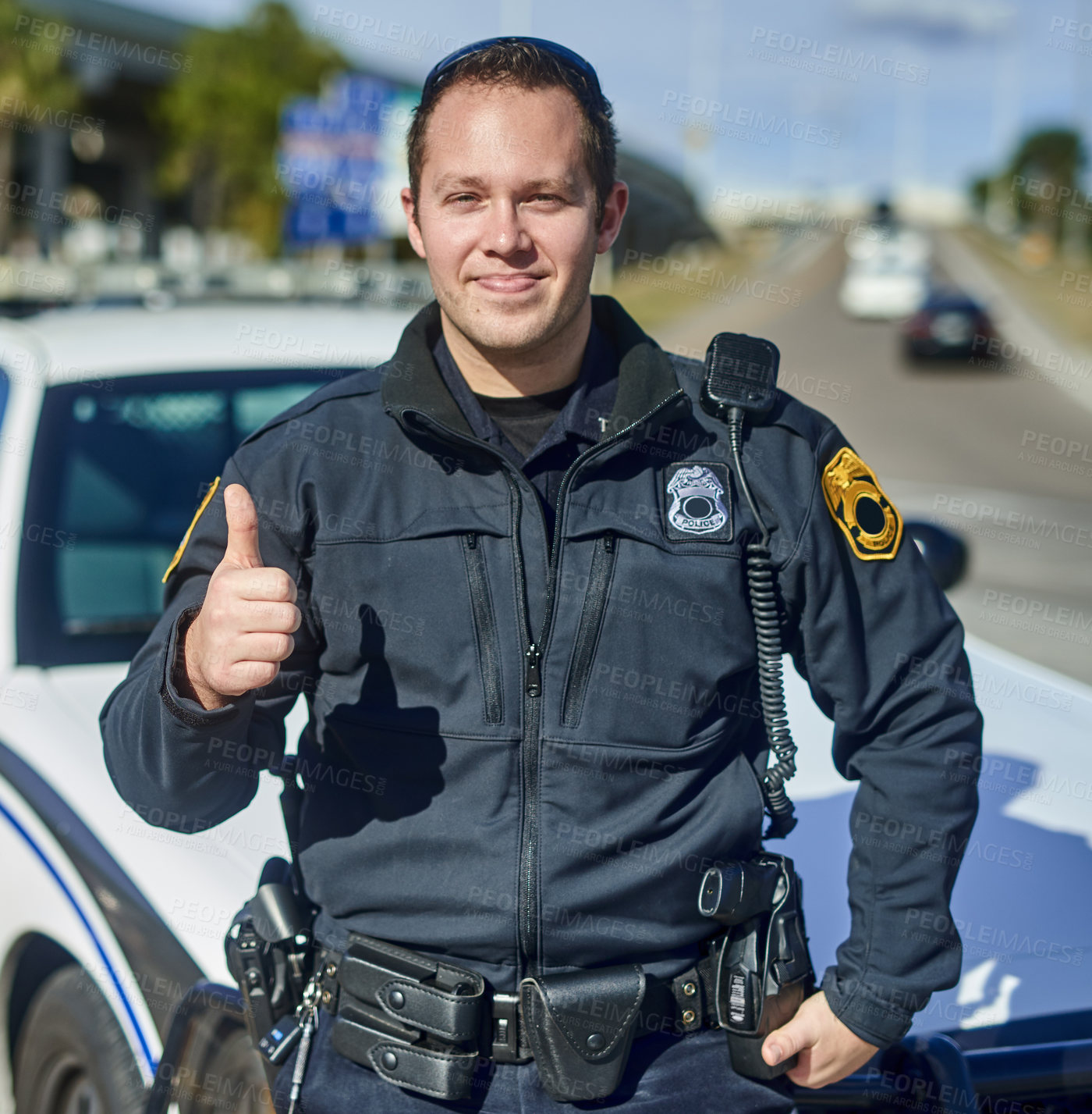 Buy stock photo Cropped portrait of a handsome young policeman giving thumbs up while out on patrol