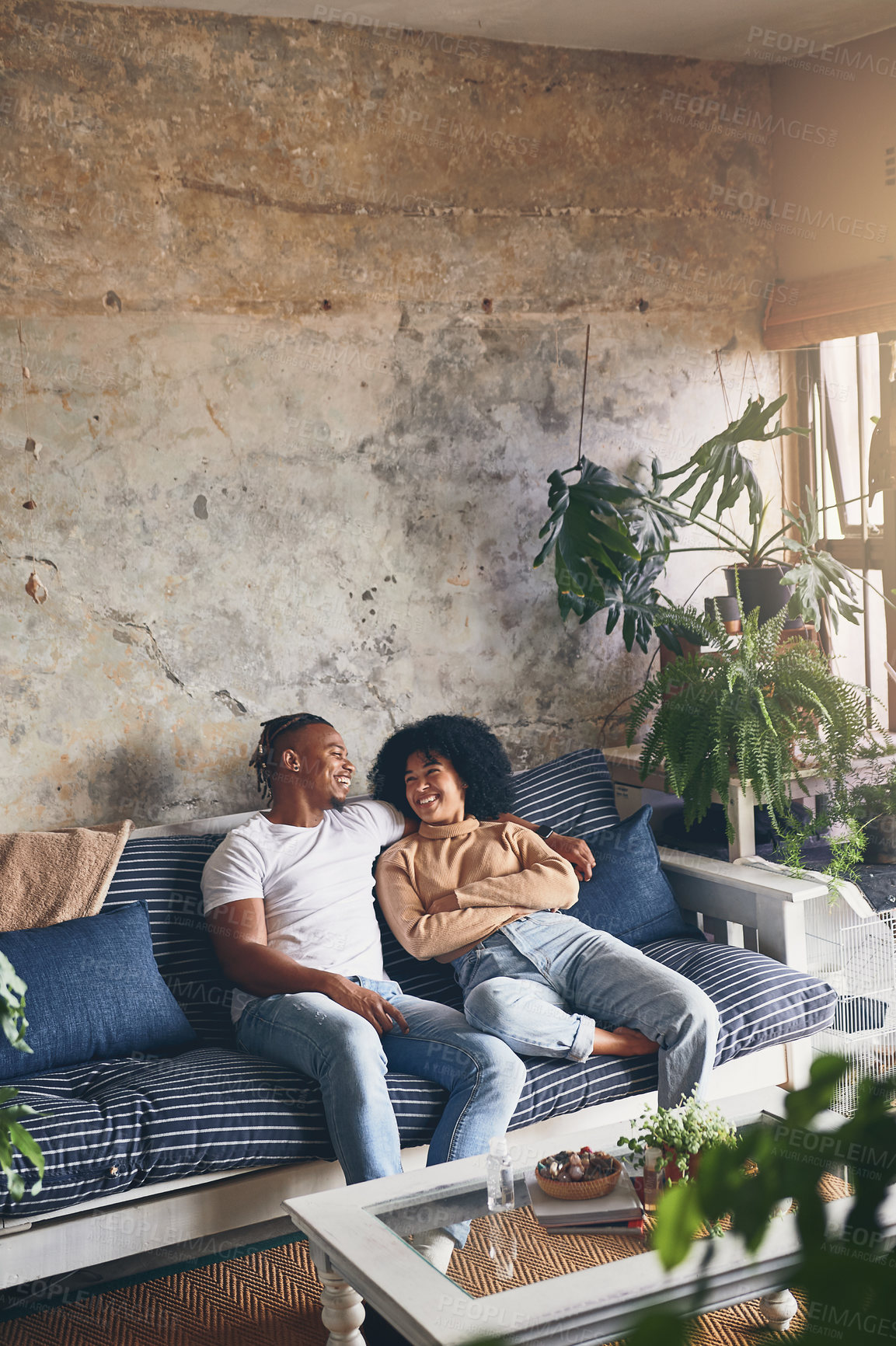 Buy stock photo Shot of a young couple relaxing together on a sofa at home