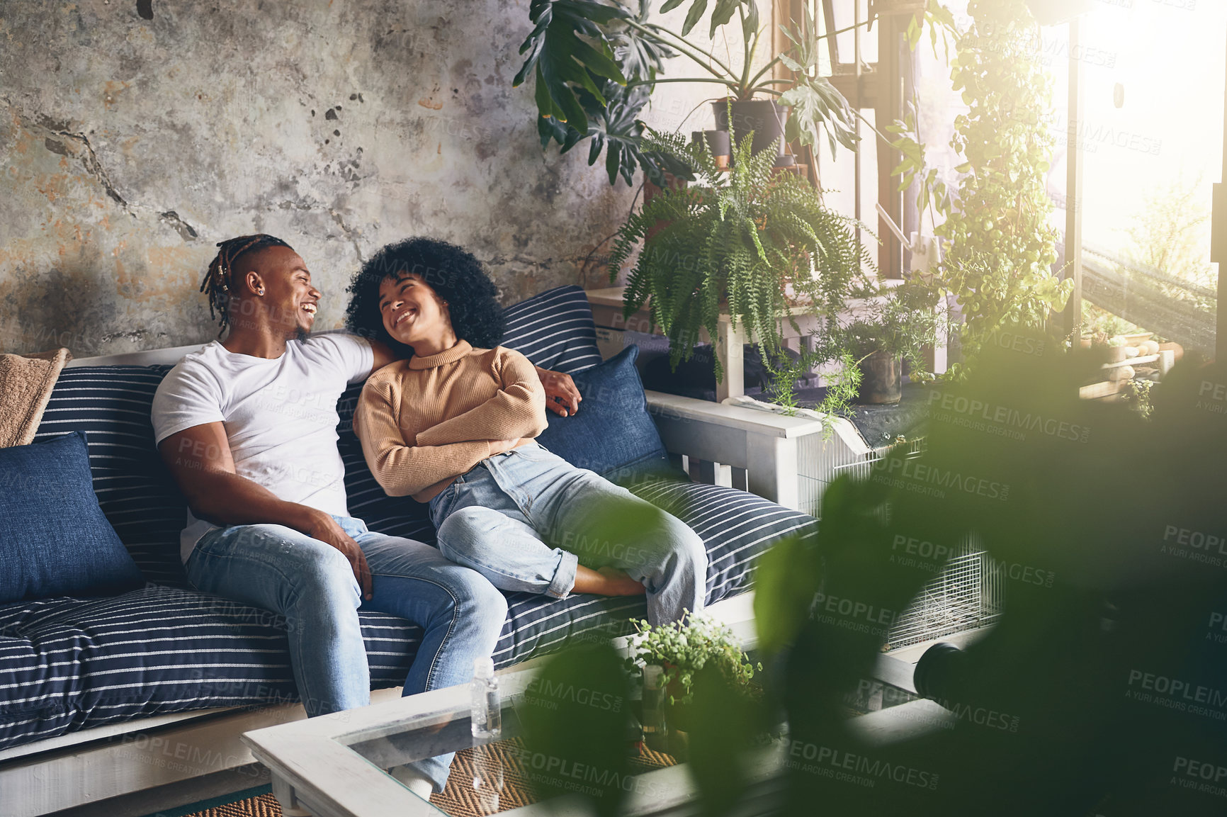 Buy stock photo Shot of a young couple relaxing together on a sofa at home