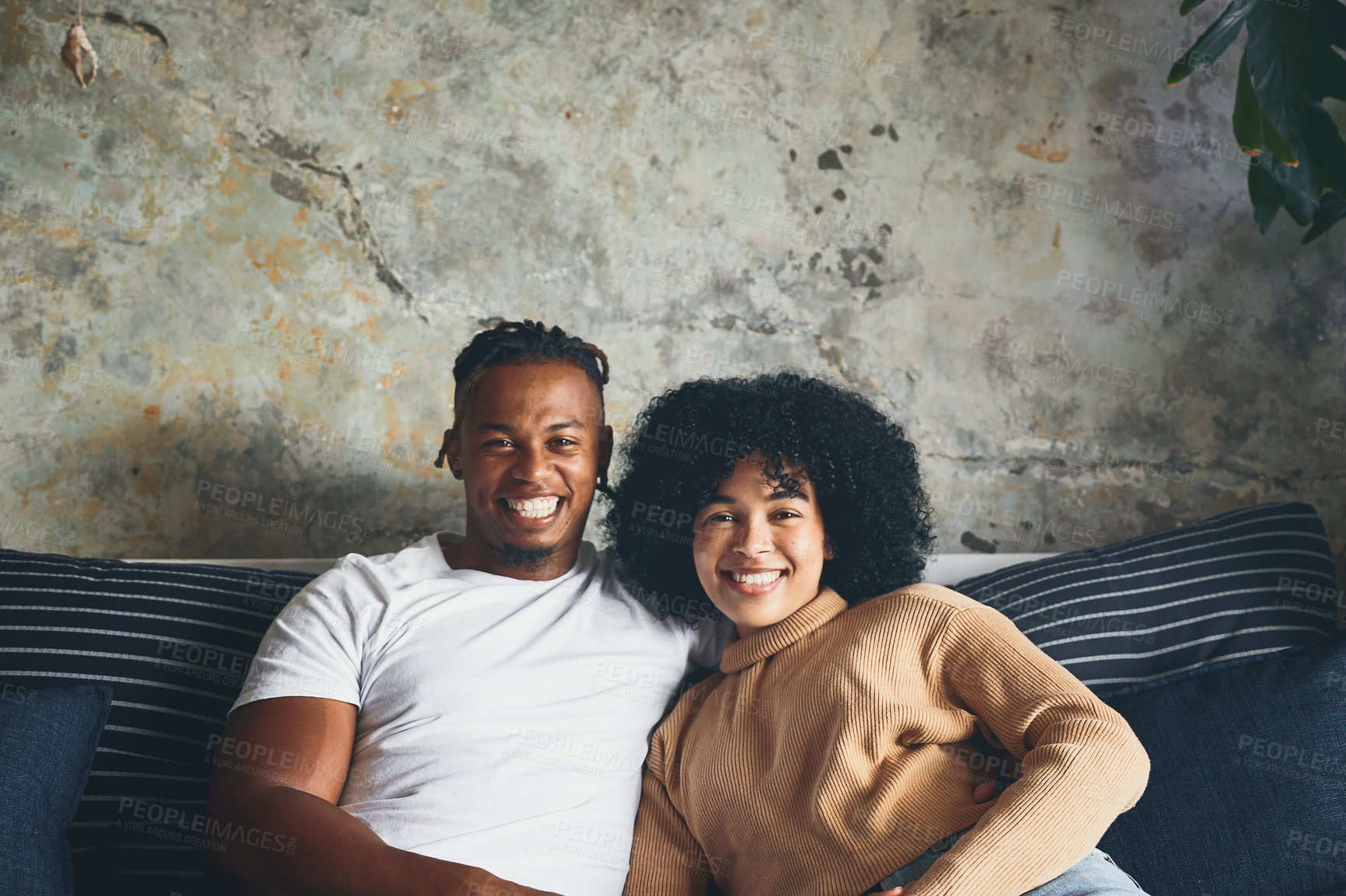 Buy stock photo Portrait of a young couple relaxing together on a sofa at home