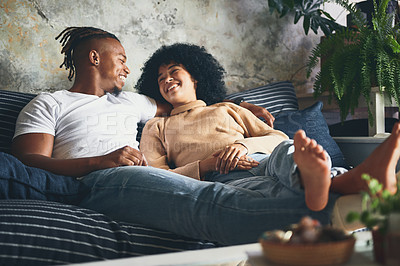 Buy stock photo Shot of a young couple relaxing together on a sofa at home