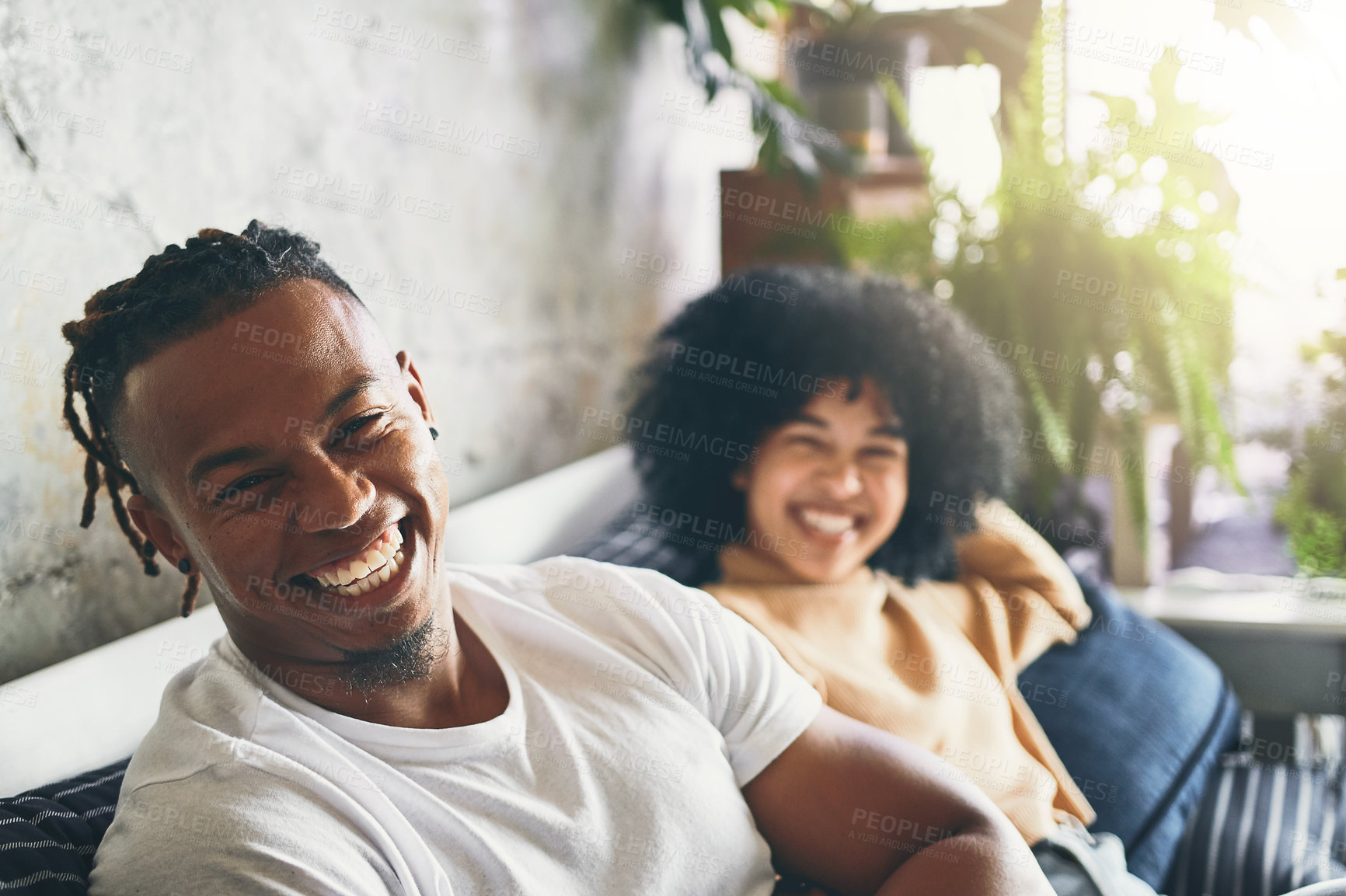 Buy stock photo Portrait of a young man relaxing with his girlfriend on a sofa at home