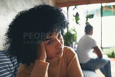 Buy stock photo Shot of a young woman looking upset after an argument with her partner at home